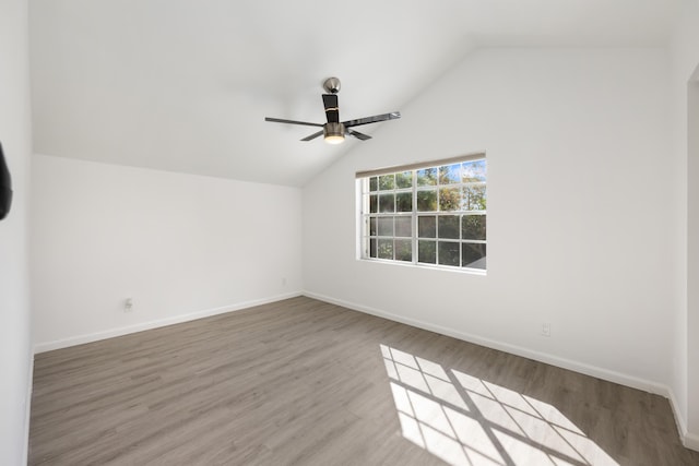 interior space with lofted ceiling, wood finished floors, a ceiling fan, and baseboards