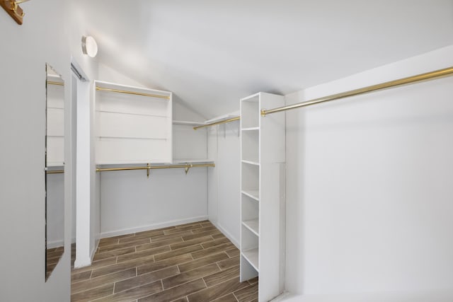 walk in closet featuring hardwood / wood-style flooring and lofted ceiling