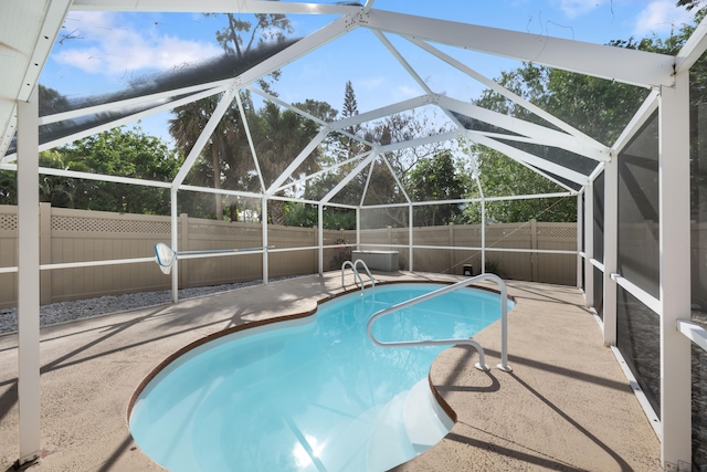 view of swimming pool featuring a patio area and glass enclosure