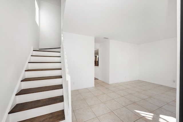 stairway featuring light tile patterned floors