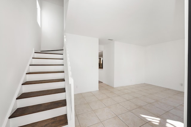 stairway featuring tile patterned flooring