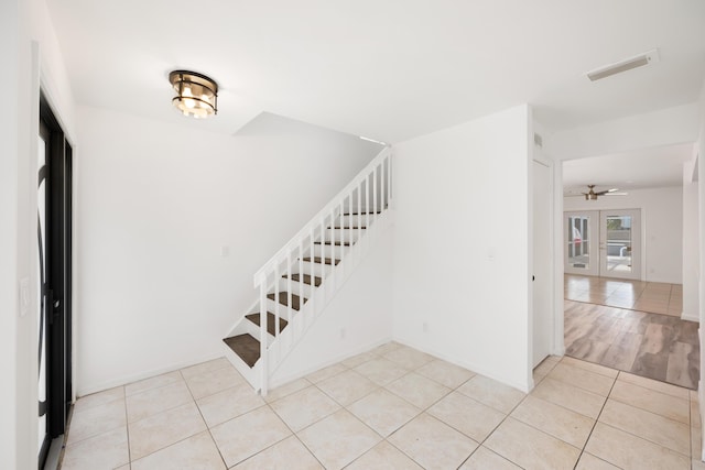 stairway featuring a ceiling fan, french doors, visible vents, and tile patterned floors