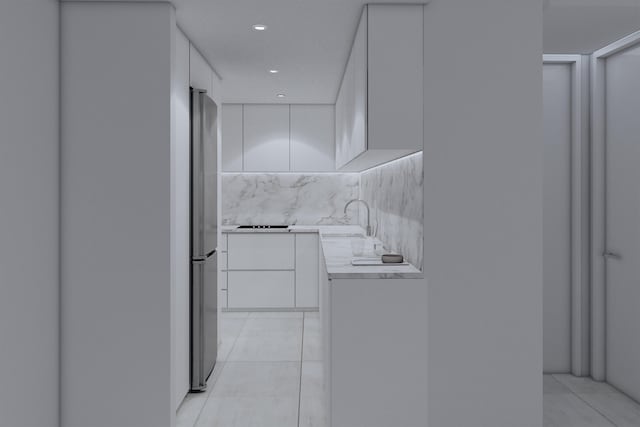 kitchen with stainless steel refrigerator, light tile patterned floors, white cabinets, decorative backsplash, and sink