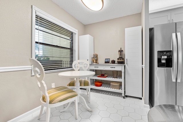 dining area with light tile patterned flooring and a textured ceiling