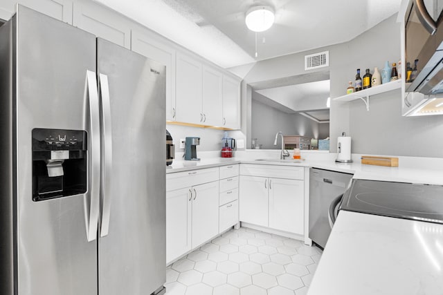 kitchen featuring light tile patterned flooring, ceiling fan, stainless steel appliances, white cabinets, and sink