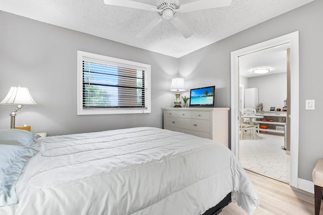 bedroom with a textured ceiling, light hardwood / wood-style flooring, and ceiling fan