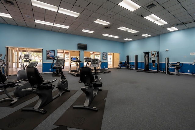 gym with carpet floors and a paneled ceiling