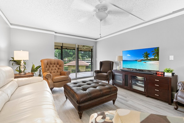 living room with light hardwood / wood-style floors, a textured ceiling, ornamental molding, and ceiling fan