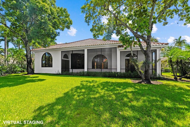 mediterranean / spanish home featuring a front lawn and a garage