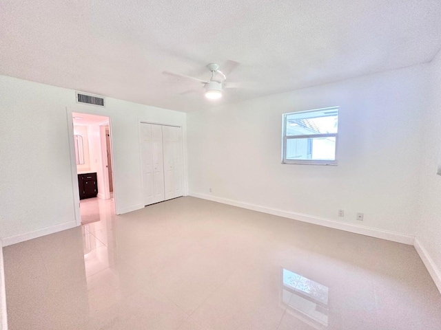 spare room with a textured ceiling and ceiling fan