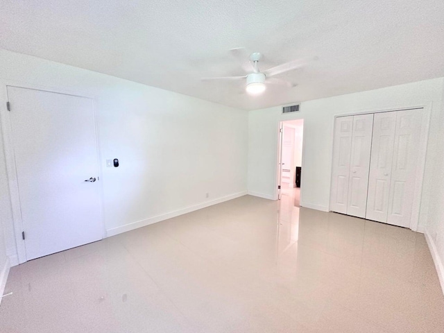 unfurnished bedroom featuring ceiling fan, a textured ceiling, and a closet