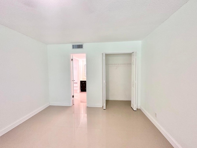 unfurnished bedroom with a closet and a textured ceiling