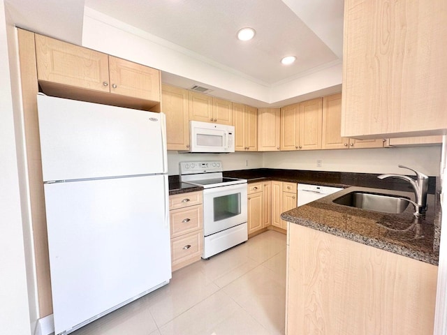 kitchen with white appliances, light brown cabinets, dark stone counters, sink, and light tile patterned floors