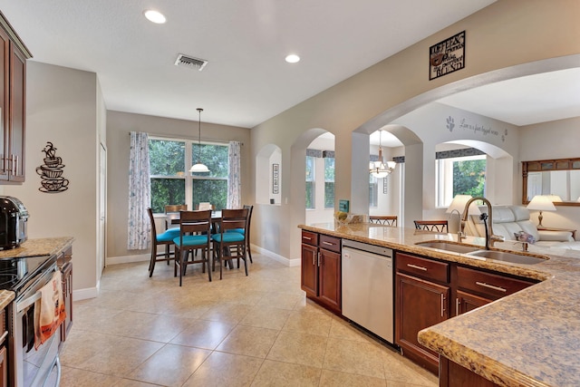 kitchen featuring sink, hanging light fixtures, stainless steel appliances, light tile patterned floors, and a chandelier