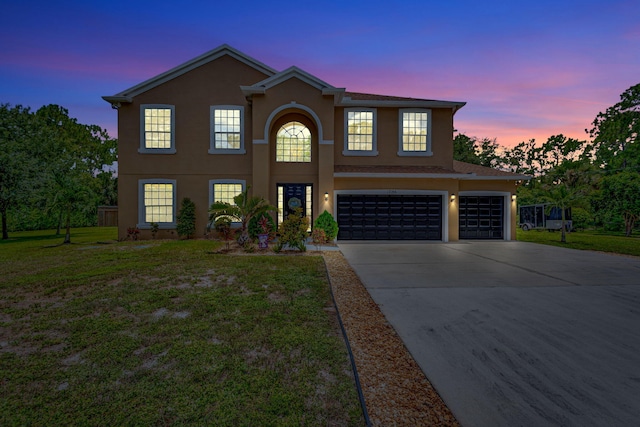 view of property with a garage and a lawn