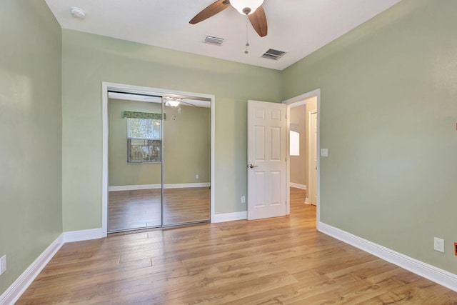 unfurnished bedroom with ceiling fan, a closet, and light hardwood / wood-style flooring