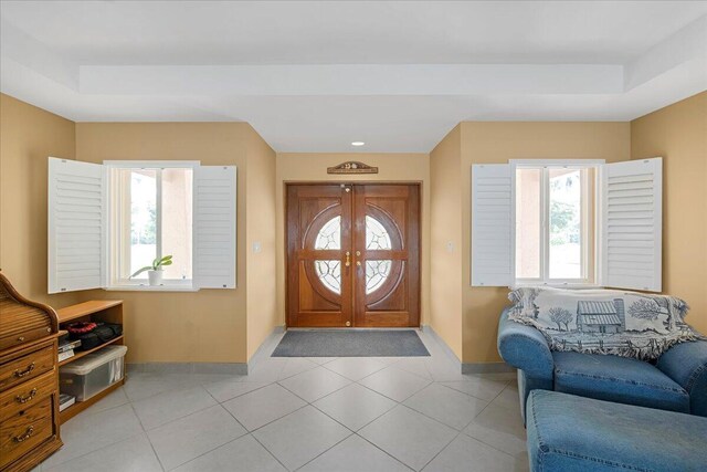 tiled foyer entrance with a raised ceiling