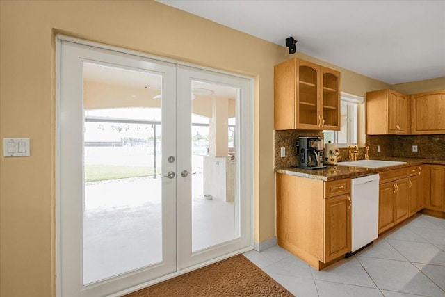 kitchen featuring french doors, sink, tasteful backsplash, dishwasher, and dark stone counters