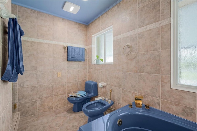 bathroom featuring a bidet, toilet, a bathing tub, and plenty of natural light