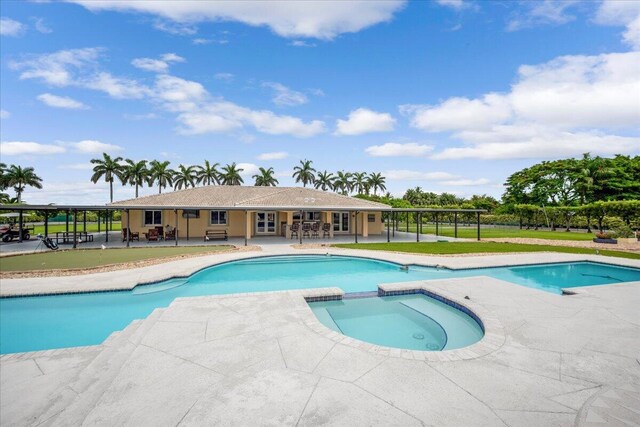 view of swimming pool featuring a patio area, an in ground hot tub, and a yard