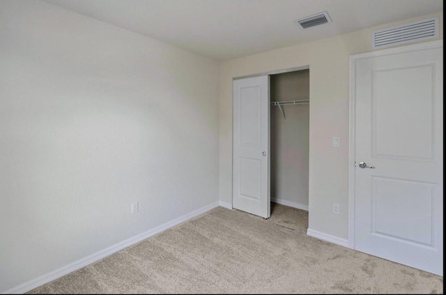 unfurnished bedroom featuring a closet and light carpet