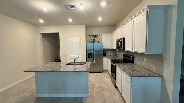 kitchen with appliances with stainless steel finishes, tasteful backsplash, sink, a center island with sink, and light tile patterned flooring