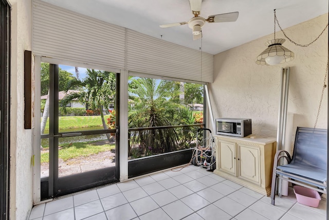 unfurnished sunroom featuring ceiling fan