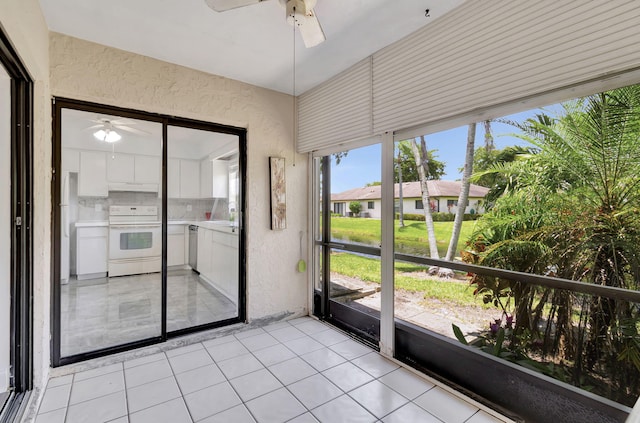 unfurnished sunroom featuring ceiling fan