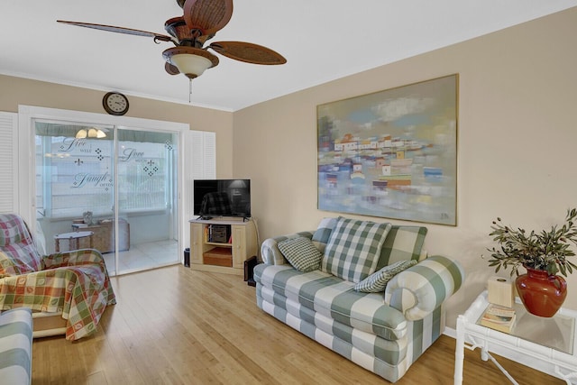 living room featuring light hardwood / wood-style floors, ceiling fan, and crown molding