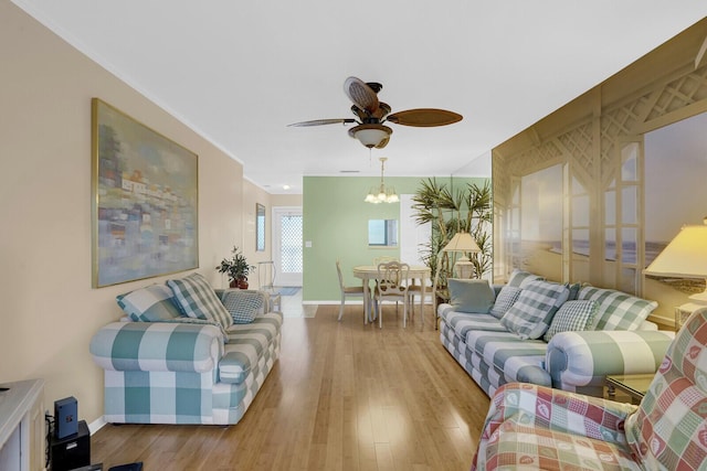 living room with light hardwood / wood-style flooring and ceiling fan with notable chandelier