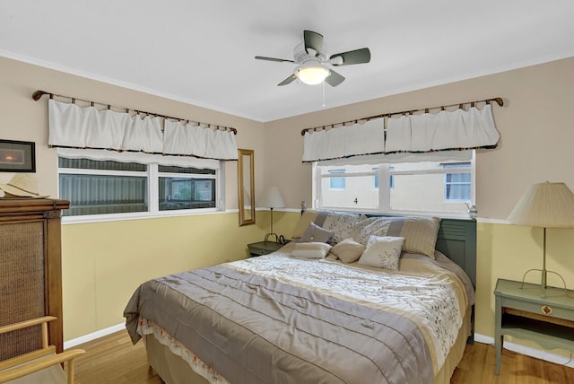 bedroom with light hardwood / wood-style floors, ceiling fan, and ornamental molding