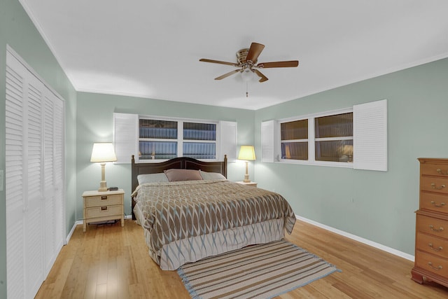 bedroom featuring ceiling fan, a closet, ornamental molding, and light hardwood / wood-style flooring