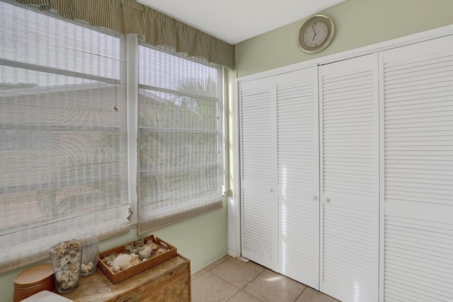 interior space with light tile patterned floors and a closet