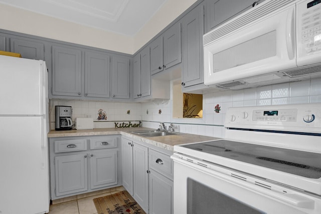 kitchen featuring gray cabinetry, sink, backsplash, white appliances, and light tile patterned floors