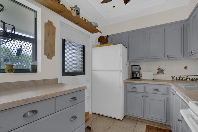 kitchen with gray cabinetry, white appliances, backsplash, ceiling fan, and light tile patterned flooring