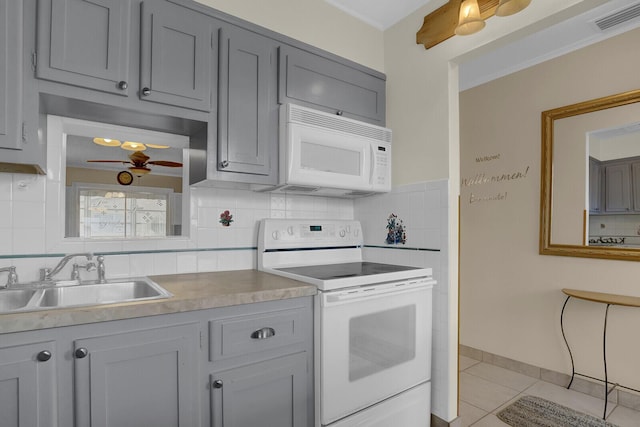 kitchen featuring light tile patterned floors, white appliances, backsplash, and sink