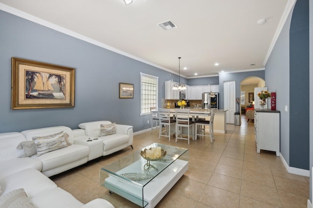 tiled living room with a chandelier and crown molding