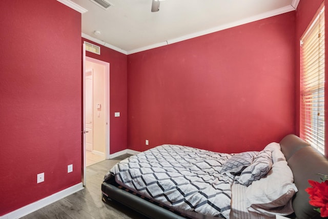 bedroom featuring hardwood / wood-style floors, ceiling fan, and ornamental molding