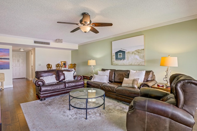 living room featuring a textured ceiling, wood-type flooring, and crown molding