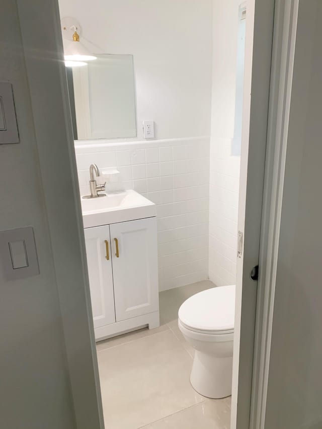 bathroom featuring vanity, tile walls, tile patterned floors, and toilet