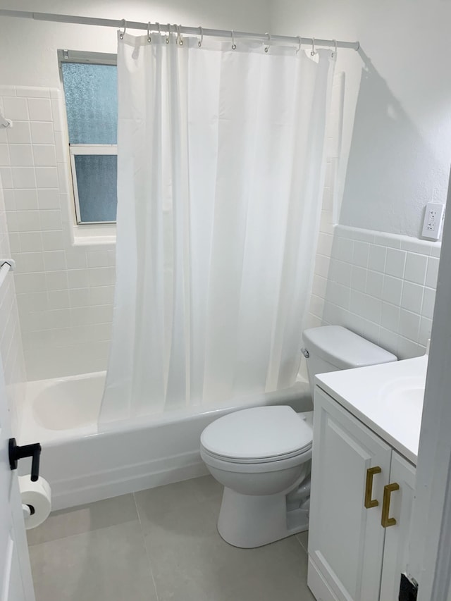 full bathroom with tile walls, tile patterned flooring, vanity, toilet, and shower / bath combo