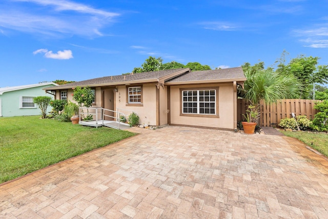 single story home with a front lawn and a patio