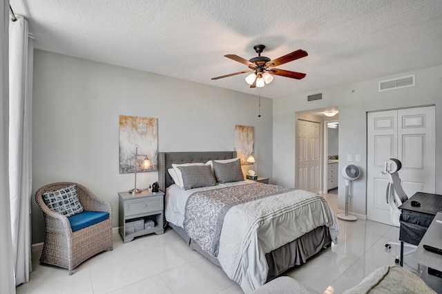 tiled bedroom with a textured ceiling and ceiling fan