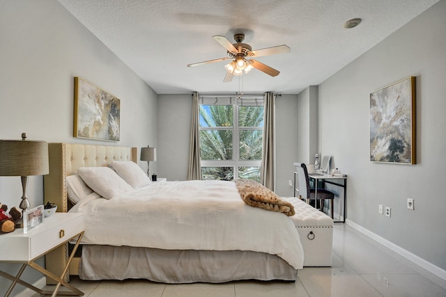 bedroom with ceiling fan, light tile patterned flooring, and a textured ceiling