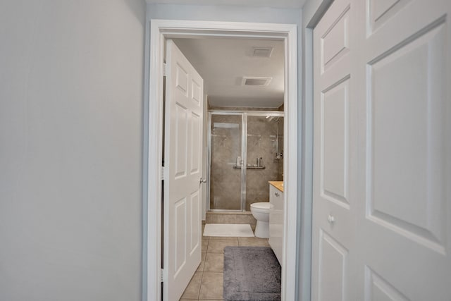 bathroom with vanity, toilet, tile patterned floors, and a shower with door