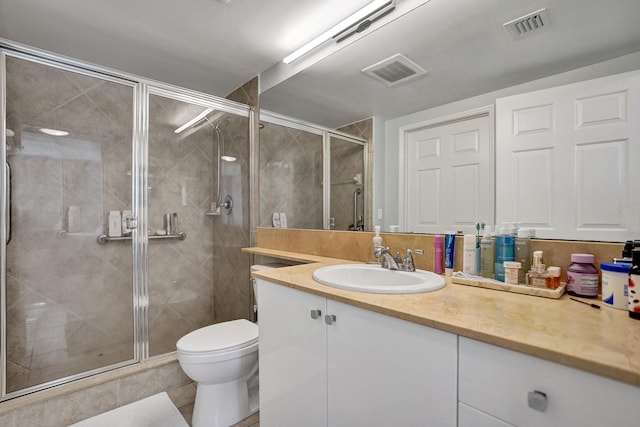 bathroom with vanity, walk in shower, toilet, and tile patterned floors