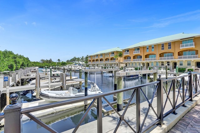 view of dock with a balcony and a water view