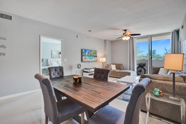 dining room featuring a textured ceiling, light tile patterned floors, and ceiling fan