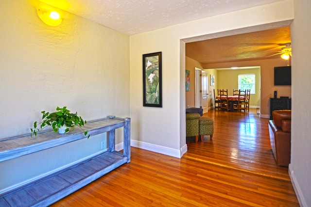 hall featuring a textured ceiling and wood-type flooring