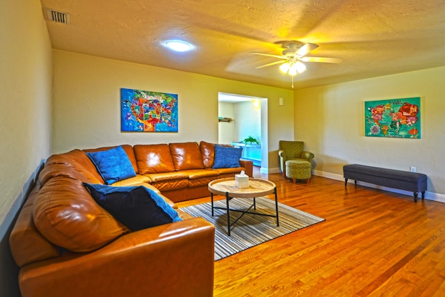 living room with wood-type flooring and ceiling fan